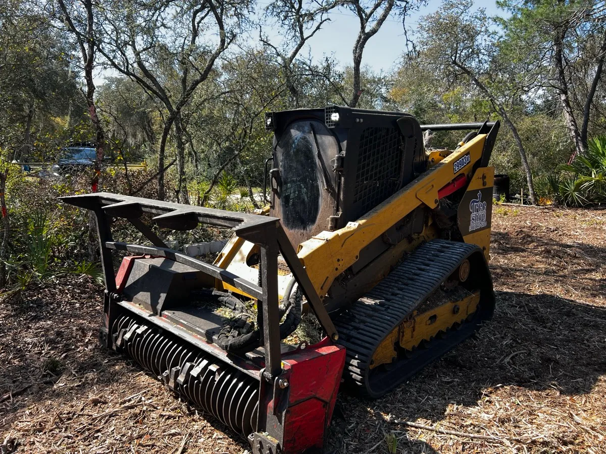 TreeShop forestry mulcher head in action grinding trees and brush — professional land clearing Florida